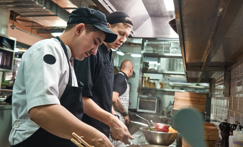 Koks bereiden een diner in een horecakeuken