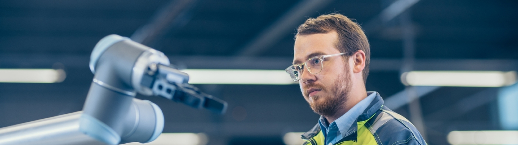 Fabrieksmedewerker stuurt robot aan