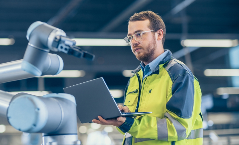 Fabrieksmedewerker stuurt robot aan