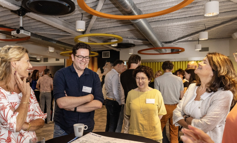 Ambtenaren uit de regio staan rond een tafel met landkaart en document