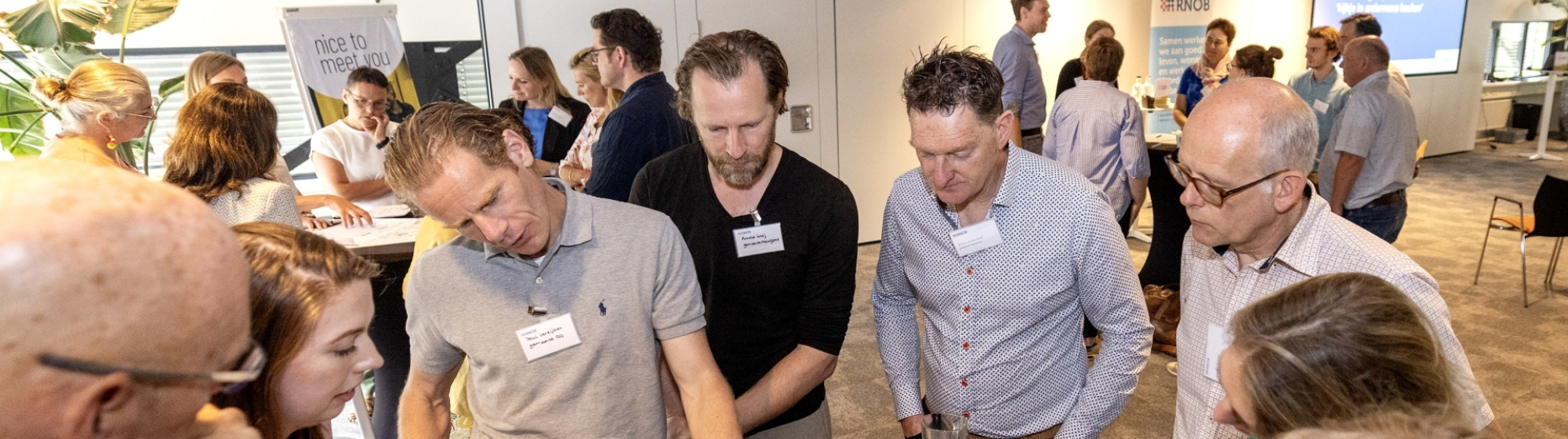 Ambtenaren uir de regio staan rond een statafel met documenten