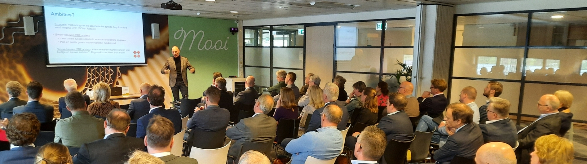 Bestuurders en ambtenaren luisteren naar presentatie over BRE-onderzoek