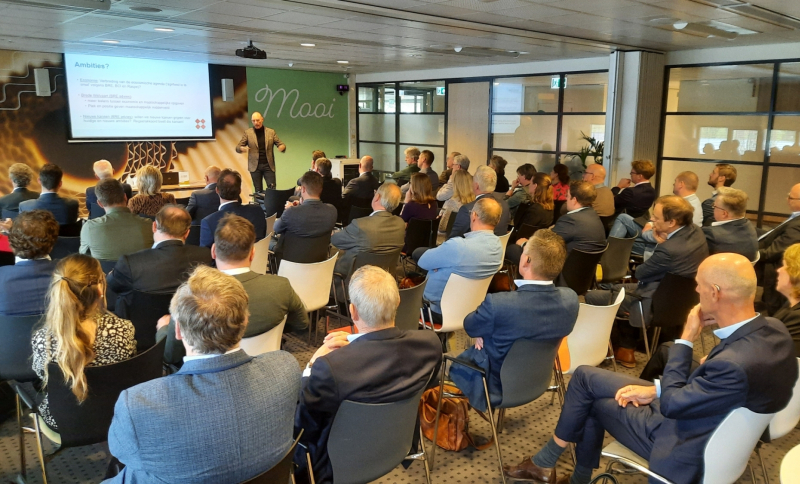 Bestuurders en ambtenaren luisteren naar presentatie over BRE-onderzoek