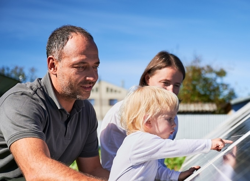 Vader, moeder en kind bij een kas