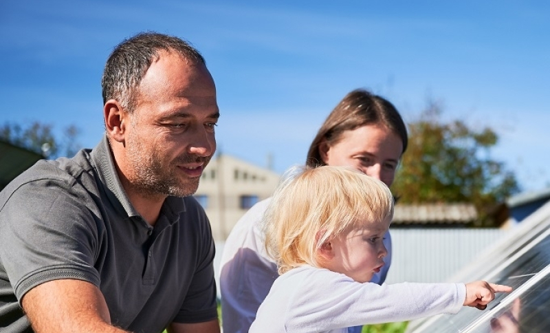 Vader, moeder en kind bij een kas