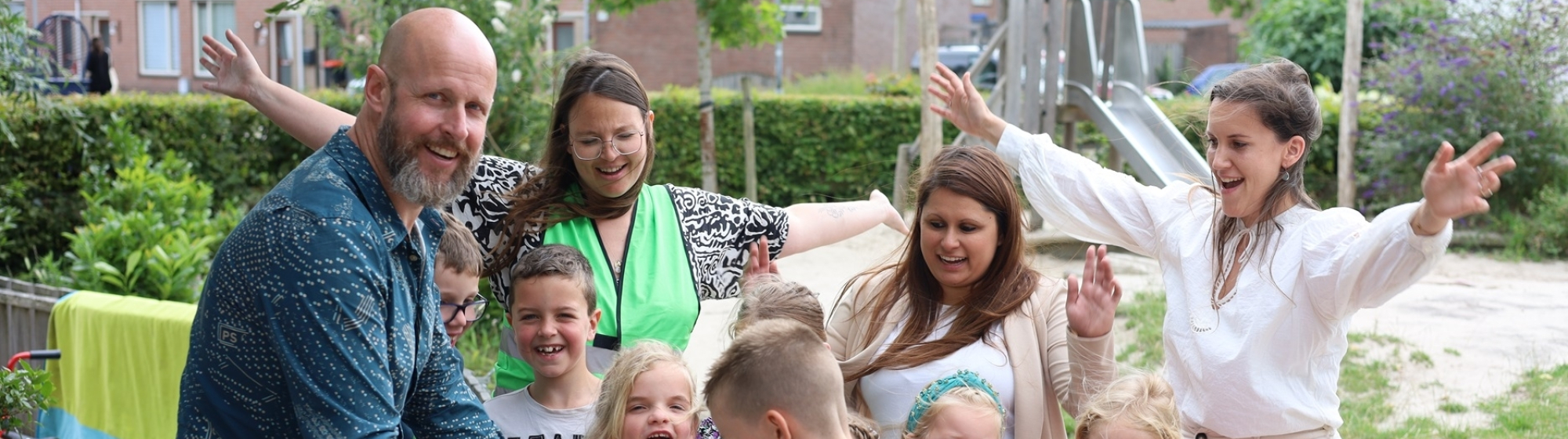 Wethouder, BSO leidsters en kinderen houden een groentenpakket vast