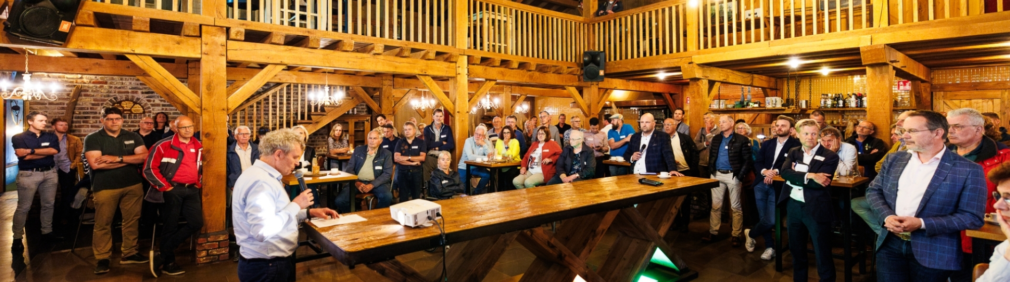 Sprekers van Zomerpeelcafé 2024 rond een tafel met publiek eromheen