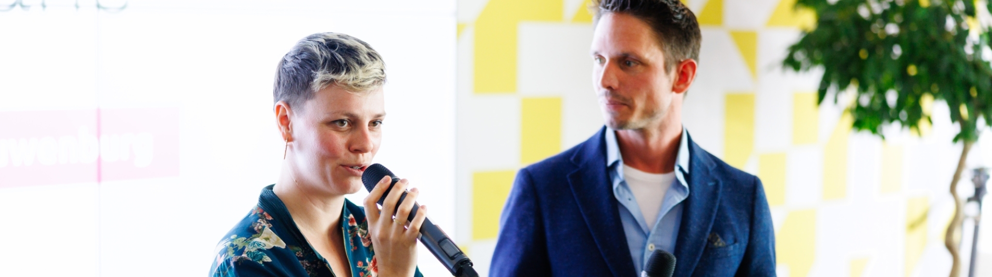 Moderator van de kickoff in gesprek met een startende onderneemster