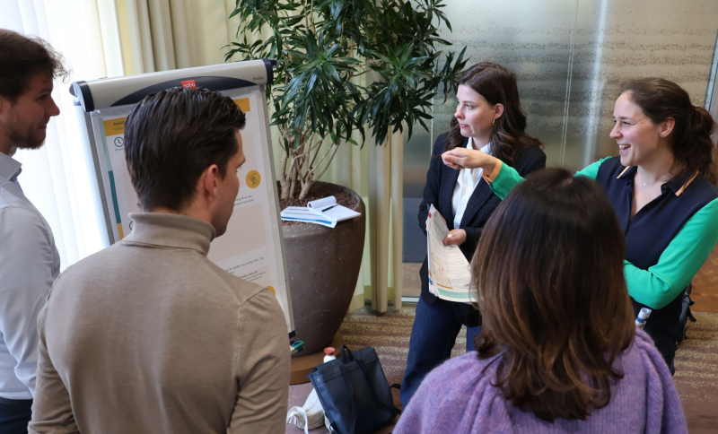 Vijf medewerkers van rijk en regio met elkaar in gesprek bij een flipover