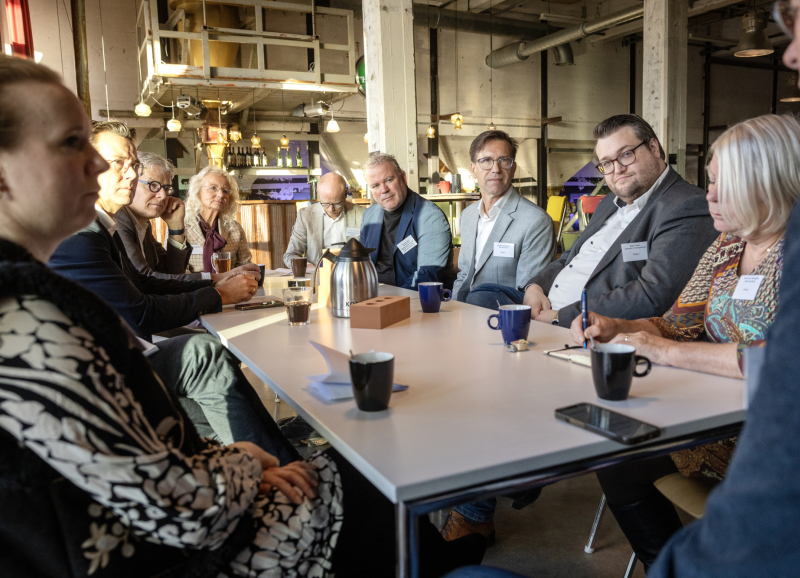 Bestuurders en ondernemers aan tafel met koffie en notitieblokken tijdens de consultatiebijeenkomst
