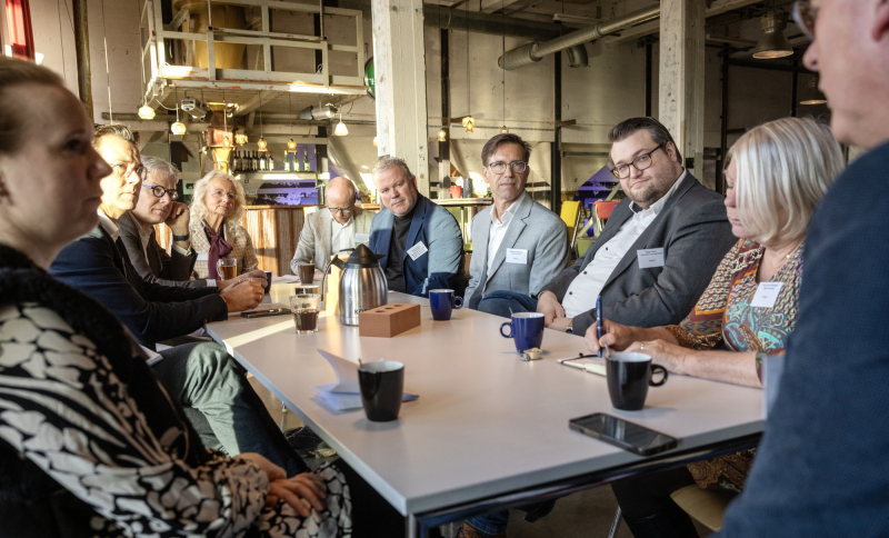 Bestuurders en ondernemers aan tafel met koffie en notitieblokken tijdens de consultatiebijeenkomst