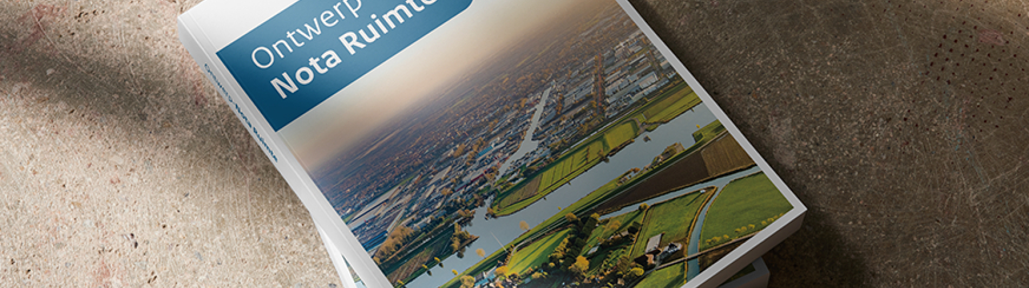 De Nota Ruimte in boekvorm, 2 exemplaren op elkaar op een stenen achtergrondboek