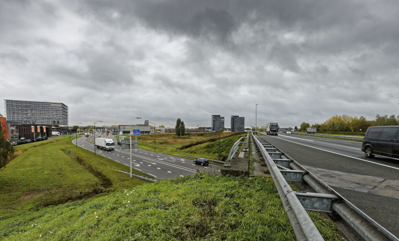Drukke verkeerssituatie op de A50 bij Veghel met vrachtwagens, auto’s en naastgelegen afritten.