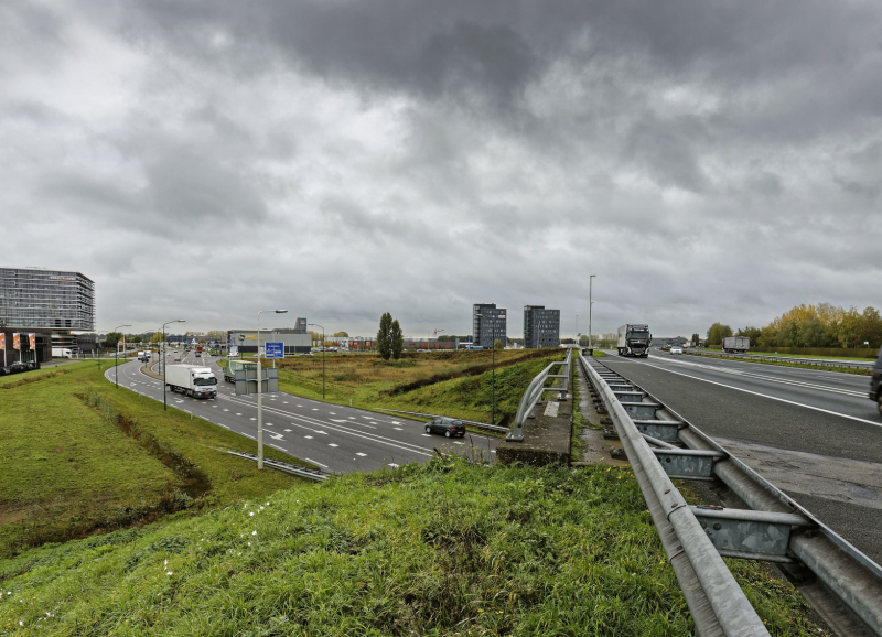 Drukke verkeerssituatie op de A50 bij Veghel met vrachtwagens, auto’s en naastgelegen afritten.
