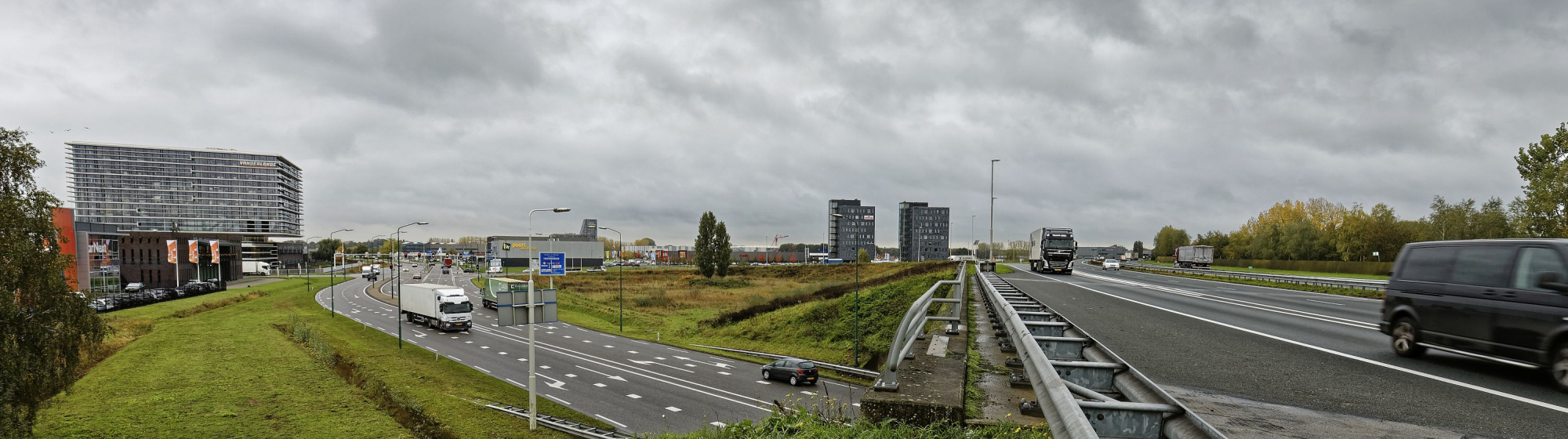Drukke verkeerssituatie op de A50 bij Veghel met vrachtwagens, auto’s en naastgelegen afritten.